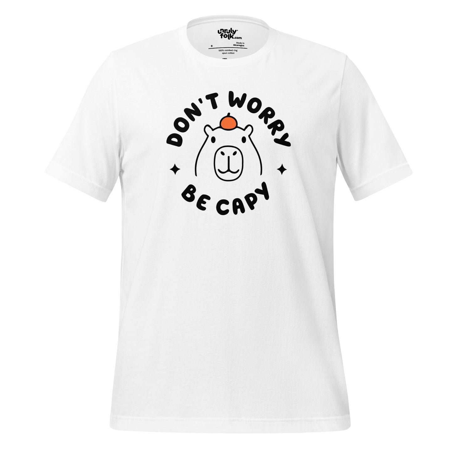 The image is of a white t-shirt with a slogan that says "Don't Worry Be Capy". It has a line drawing of a capybara with an orange on its head. From the Unruly Folk brand.